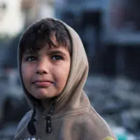 A Palestinian boy at the site of Israeli strikes on a mosque and houses, in Rafah in the southern Gaza Strip on January 25. | Ibraheem Abu Mustafa/ Reuters